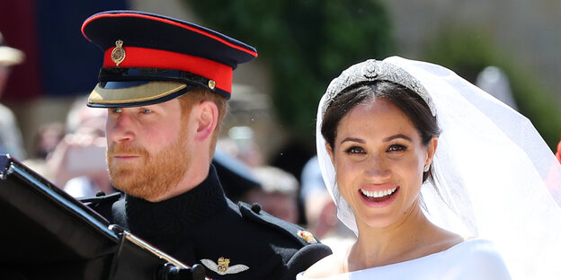 Meghan Markle sitzt lächelnd neben Prinz Harry Meghan Markle sitzt lächelnd neben Prinz Harry