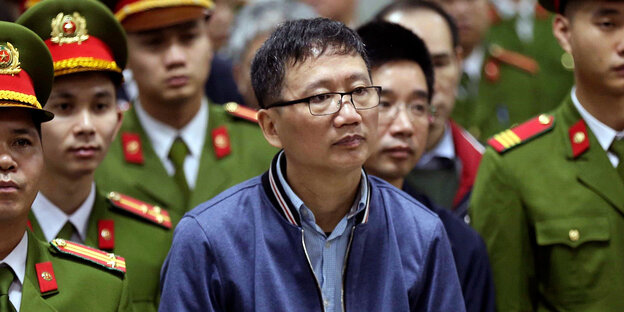 Der vietnamesische Geschäftsmann, Trinh Xuan Than, steht neben sehr vielen vietnamesischn Staatsbediensteten Der vietnamesische Geschäftsmann, Trinh Xuan Than, steht neben sehr vielen vietnamesischn Staatsbediensteten