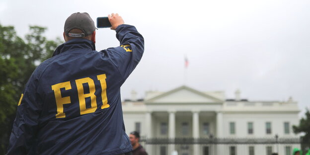 ein Mann mit einer FBI-Jacke macht ein Foto vom Weißen Haus ein Mann mit einer FBI-Jacke macht ein Foto vom Weißen Haus