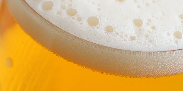 Eine Schaumkrone auf einem Glas Bier Eine Schaumkrone auf einem Glas Bier