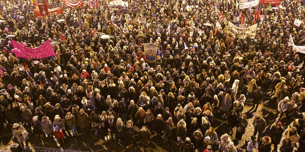 Viele Männer und Frauen stehen in Mänteln auf einem Platz in Oslo Viele Männer und Frauen stehen in Mänteln auf einem Platz in Oslo