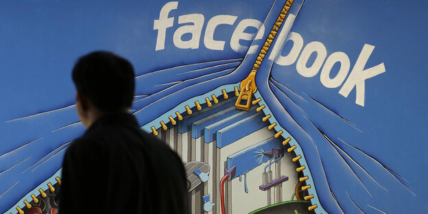 Ein Mann läuft an einem Facebook-Wandgemälde vorbei Ein Mann läuft an einem Facebook-Wandgemälde vorbei
