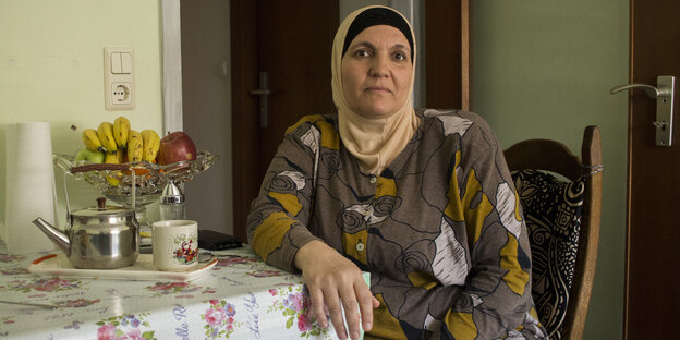 Eine Frau, Ftiem Almousa, sitzt am Küchentisch Eine Frau, Ftiem Almousa, sitzt am Küchentisch