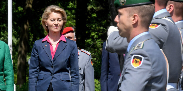 In der linken Bildhälfte eine Frau in Anzug, in der rechten Bildhälfte ein Soldat in Uniform In der linken Bildhälfte eine Frau in Anzug, in der rechten Bildhälfte ein Soldat in Uniform