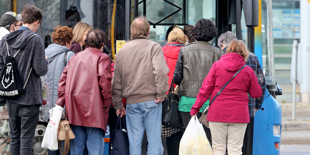 Menschen drängen sich vor einem Bus Menschen drängen sich vor einem Bus