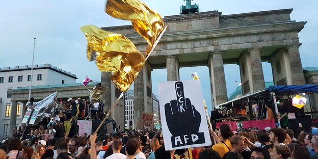 Viele Menschen mit Plakaten und goldenen Fahnen, zwei Wagen vor dem Brandenburger Tor Viele Menschen mit Plakaten und goldenen Fahnen, zwei Wagen vor dem Brandenburger Tor