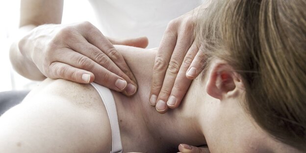 Hände einer Physiotherapeutin bei Nackenmassage Hände einer Physiotherapeutin bei Nackenmassage