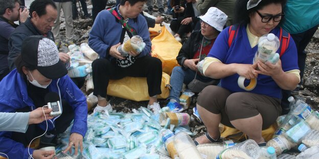 Leute befüllen Plastikflaschen Leute befüllen Plastikflaschen