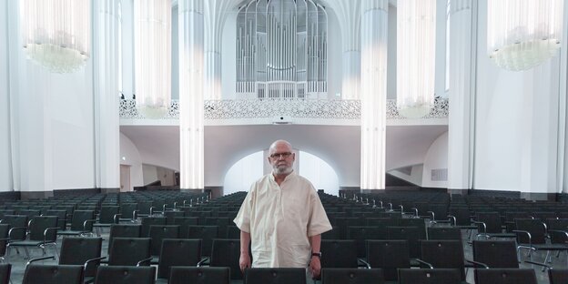 Mann mit weißem Hemb steht in einer Kirche Mann mit weißem Hemb steht in einer Kirche