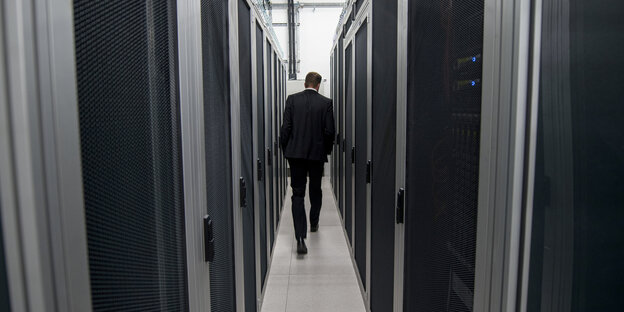 Ein Mitarbeiter der Firma DE-CIX geht zwischen Server-Schränken hindurch Ein Mitarbeiter der Firma DE-CIX geht zwischen Server-Schränken hindurch