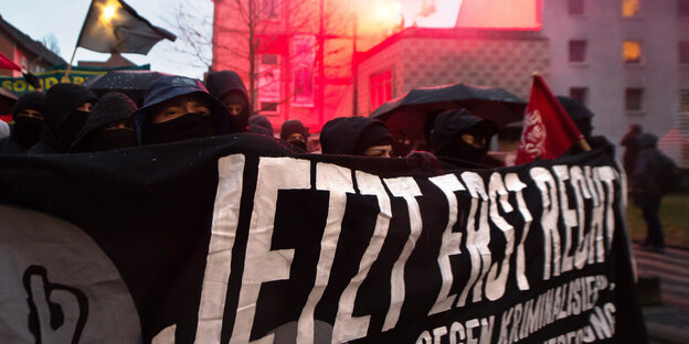 Vermummte Demonstranten hinter einem Transparent Vermummte Demonstranten hinter einem Transparent