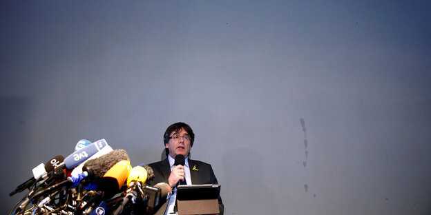 Puigdemont spricht auf einer Pressekonferenz in Mikrofone Puigdemont spricht auf einer Pressekonferenz in Mikrofone