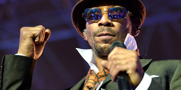 Demba Nabé mit Hut, Sonnenbrille und Mikrofon Demba Nabé mit Hut, Sonnenbrille und Mikrofon