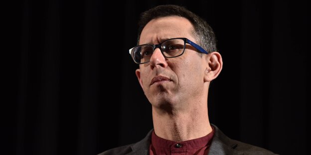 Ein Mann mit Brille vor schwarzem Hintergrund Ein Mann mit Brille vor schwarzem Hintergrund