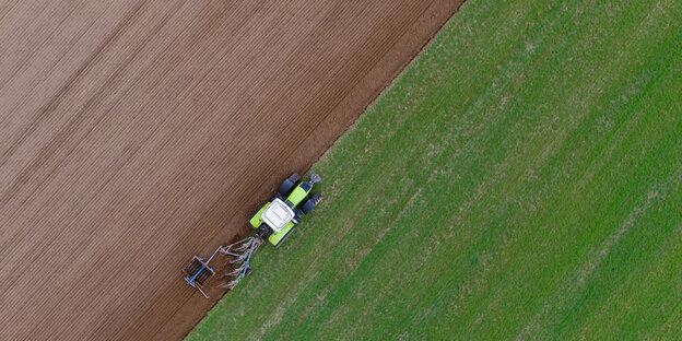 ein Traktor auf einem halb bearbeiteten Feld ein Traktor auf einem halb bearbeiteten Feld