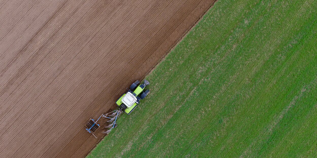 ein Traktor auf einem halb bearbeiteten Feld