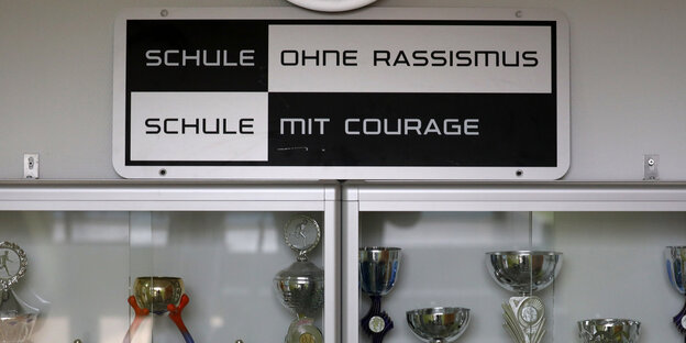 Das Logo von "Schule ohne Rassismus" hängt über einem Schrank voller Pokale Das Logo von "Schule ohne Rassismus" hängt über einem Schrank voller Pokale