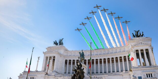 Flugzeuge zeichnen Rauchstreifen in den italienischen Nationalfarben in den Himmel über Rom