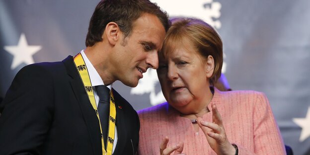 Macron und Merkel stecken die Köpfe zusammen. Macron und Merkel stecken die Köpfe zusammen.