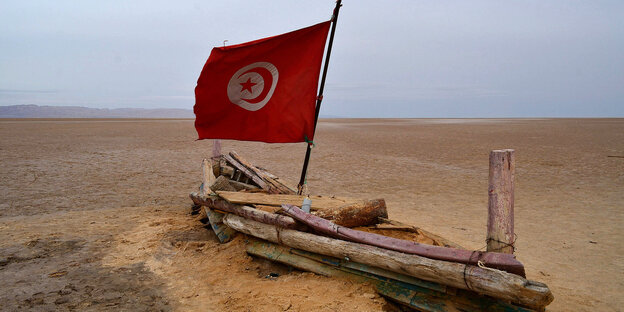 Bootartige Struktur auf Sand mit tunesischer Flagge Bootartige Struktur auf Sand mit tunesischer Flagge