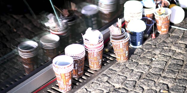 Viele leere Plastikkaffeebecher stehen auf dem Boden Viele leere Plastikkaffeebecher stehen auf dem Boden