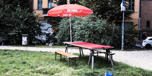 ein Tisch und Bänke und ein Sonnenschirm mit Linkspartei-Logo ein Tisch und Bänke und ein Sonnenschirm mit Linkspartei-Logo