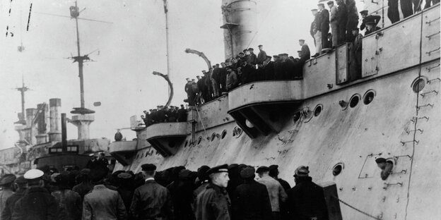 Matrosen, die auf und vor einem Schiff stehen Matrosen, die auf und vor einem Schiff stehen