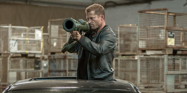 Til Schweiger als Nick Tschiller ragt mit seinem Oberkörper aus dem Dach eines Autos, er schultert dabei ein Geschütz, mit dem er in eine Richtung zielt Til Schweiger als Nick Tschiller ragt mit seinem Oberkörper aus dem Dach eines Autos, er schultert dabei ein Geschütz, mit dem er in eine Richtung zielt