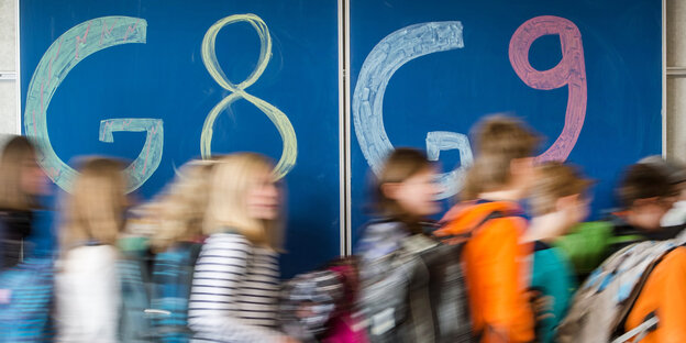 Schüler vor einer Tafel, auf der G8/G9 steht Schüler vor einer Tafel, auf der G8/G9 steht