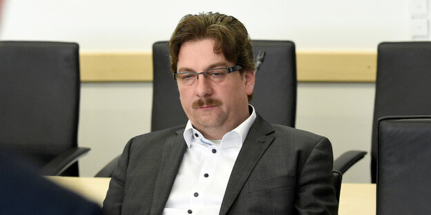 Ein Mann mit Oberlippenbart und Brille Ein Mann mit Oberlippenbart und Brille