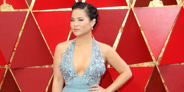 Die Schauspielerin Kelly Marie Tran steht in einem Kleid vor einer roten Wand und posiert für Fotografen Die Schauspielerin Kelly Marie Tran steht in einem Kleid vor einer roten Wand und posiert für Fotografen