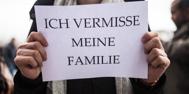Jemand hält ein Schild hoch, auf dem "Ich vermisse meine Familie" steht Jemand hält ein Schild hoch, auf dem "Ich vermisse meine Familie" steht