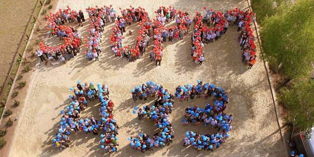 Viele Menschen mit Luftballons bilden zusammen die Wörter "Stoppt A33" Viele Menschen mit Luftballons bilden zusammen die Wörter "Stoppt A33"