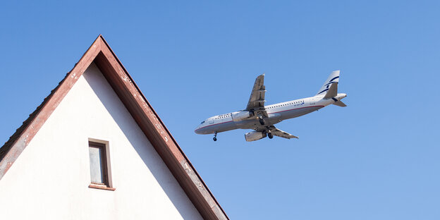 Ein Flugzeug fliegt tief über ein Wohnhaus Ein Flugzeug fliegt tief über ein Wohnhaus