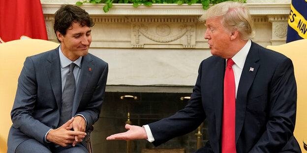 Zwei Männer sitzen nebeneinander, der eine ist Donald Trump und reicht dem anderen die Hand. Dieser macht keine Anstalten, die Hand zu nehmen. Es ist Kanadas Premierminister Justin Trudeau Zwei Männer sitzen nebeneinander, der eine ist Donald Trump und reicht dem anderen die Hand. Dieser macht keine Anstalten, die Hand zu nehmen. Es ist Kanadas Premierminister Justin Trudeau