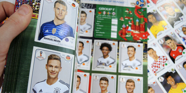 Eine Hand hält ein Sammelalbum Eine Hand hält ein Sammelalbum