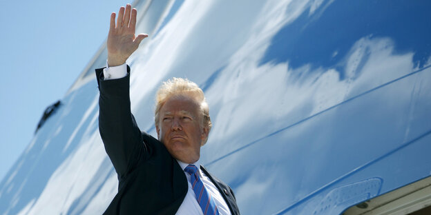 Donald Trump winkt mit dem rechten Arm Donald Trump winkt mit dem rechten Arm