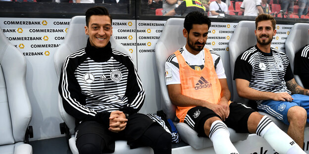 Die Fußballspieler Mesut Özil, İlkay Gündoğan und Kevin Trapp (von links nach rechts) sitzen in Sportkleidung nebeneinander auf der Bank Die Fußballspieler Mesut Özil, İlkay Gündoğan und Kevin Trapp (von links nach rechts) sitzen in Sportkleidung nebeneinander auf der Bank