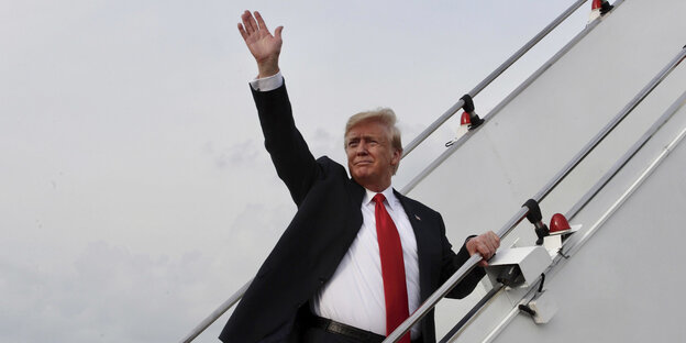 US-Präsident Donald Trump steigt in ein Flugzeug und winkt US-Präsident Donald Trump steigt in ein Flugzeug und winkt
