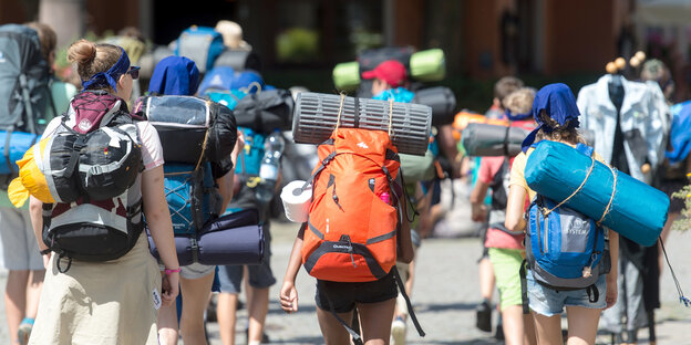 Mehrere Jugendliche, die große Rucksäcke tragen, von hinten Mehrere Jugendliche, die große Rucksäcke tragen, von hinten