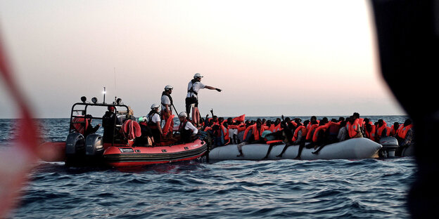 Menschen steigen auf Schlauchboote Menschen steigen auf Schlauchboote