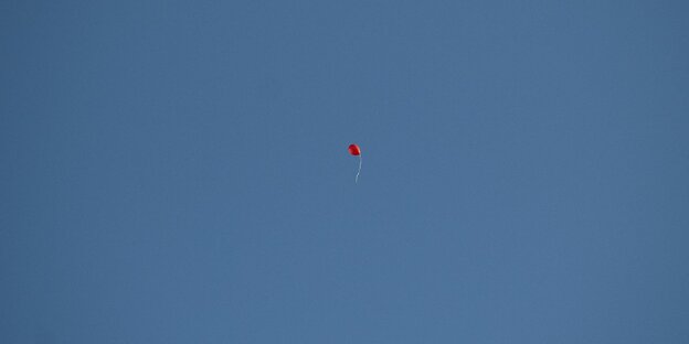 Ein einsamer roter SPD-Ballon fliegt durch den blauen Himmel Ein einsamer roter SPD-Ballon fliegt durch den blauen Himmel