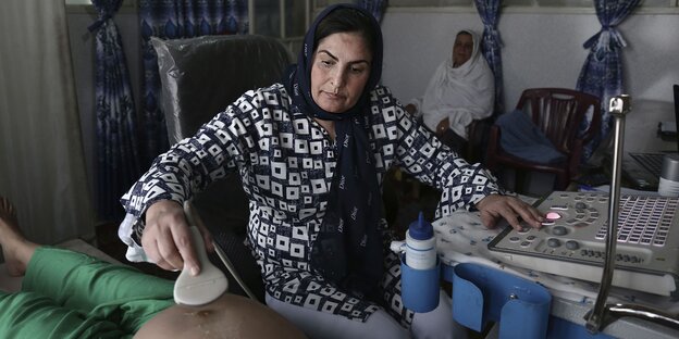 Frau mit Koptuch hilft Patienten Frau mit Koptuch hilft Patienten