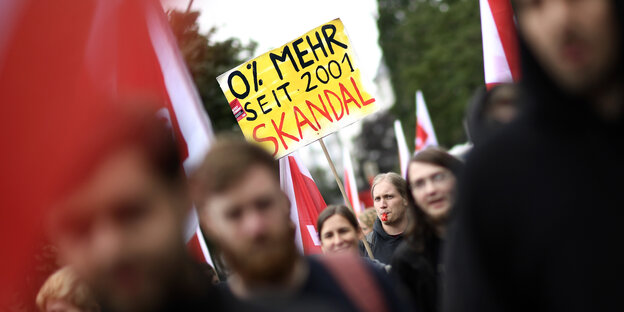 Blick in einen Demozug auf ein Plakat mit der Aufschrift "0 % mehr seit 2001 - Skandal" Blick in einen Demozug auf ein Plakat mit der Aufschrift "0 % mehr seit 2001 - Skandal"