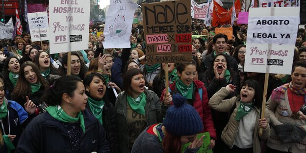 Eine große Demonstrantinnengruppe mit grünen Halstüchern demonstriert in Argentinien mit Plakaten wie „Legale Abtreibung im Krankenhaus“ für das Recht auf Schwangerschaftsabbrüche Eine große Demonstrantinnengruppe mit grünen Halstüchern demonstriert in Argentinien mit Plakaten wie „Legale Abtreibung im Krankenhaus“ für das Recht auf Schwangerschaftsabbrüche