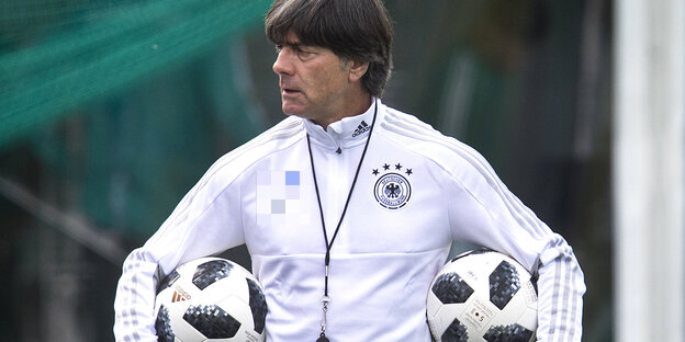 Trainer Joachim Löw trägt unter jedem Arm einen Ball Trainer Joachim Löw trägt unter jedem Arm einen Ball