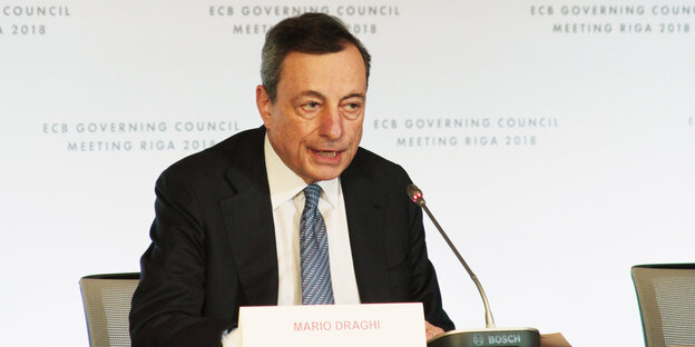Mario Draghi sitzt vor einem Mikrofon Mario Draghi sitzt vor einem Mikrofon