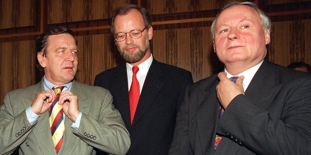 Gerhard Schröder und Oskar Lafontaine stehen links und rechts neben Rudolf Scharpin und richten ihre Krawatten Gerhard Schröder und Oskar Lafontaine stehen links und rechts neben Rudolf Scharpin und richten ihre Krawatten