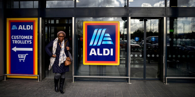Eine Frau verlässt einen Aldi-Supermarkt Eine Frau verlässt einen Aldi-Supermarkt