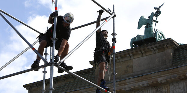 Männer bauen ein Gerüst vor dem Brandenburger Tor auf Männer bauen ein Gerüst vor dem Brandenburger Tor auf